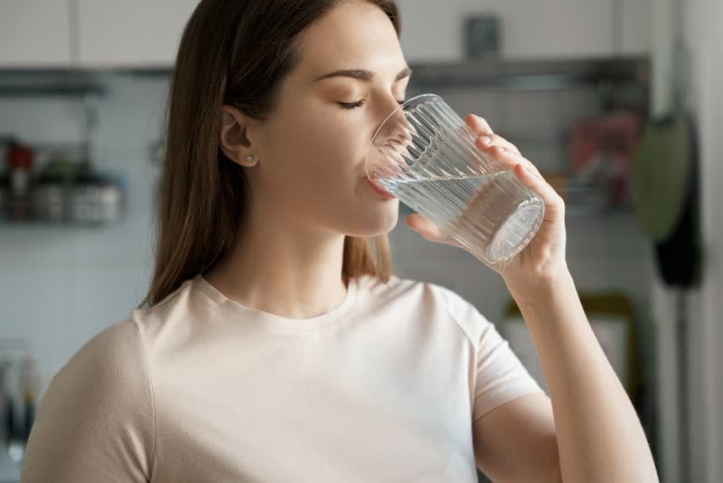 Donna che beve dell'acqua da un bicchiere. Nel diabete insipido è frequente un aumento nell'assunzione di liquidi